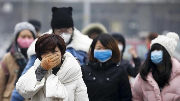  Người dân Bắc Kinh đeo khẩu trang khi đi ra đường hôm 8/12. Ảnh: AP 