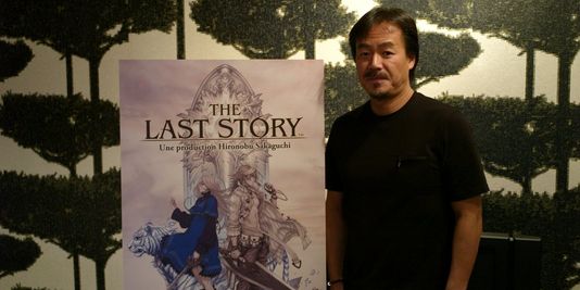 Ông Sakuguchi bên cạnh poster của sản phẩm The Last Story