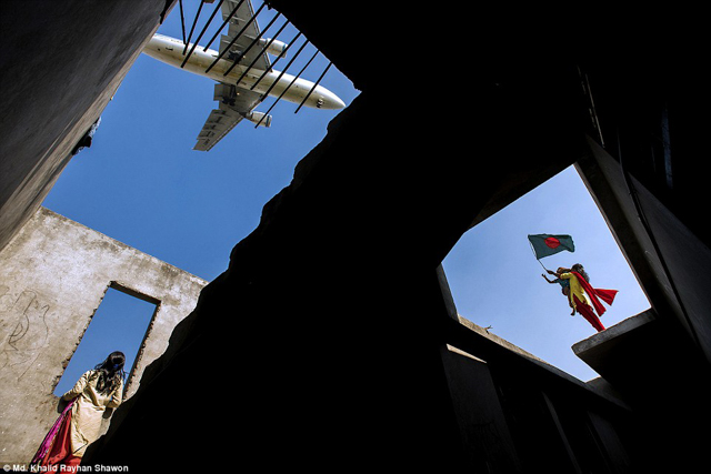 Giải sắc m&agrave;u: Kỷ niệm chiến thắng của Md. Khalid Rayhan Shawon. Những đứa trẻ ở một c&ocirc;ng tr&igrave;nh bỏ hoang gần s&acirc;n bay quốc tế Dhaka đang ngắm m&aacute;y bay hạ c&aacute;nh, một đứa trẻ trong số đ&oacute; đang vẫy l&aacute; cờ quốc gia để kỷ niệm ng&agrave;y chiến thắng của Bangladesh - ng&agrave;y 16/12.