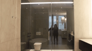 Cửa phòng tắm là một thiết kế vô cùng độc đáo. Tấm kính trong suốt sẽ được phủ sương mờ ngay sau khi ấn công tắc.