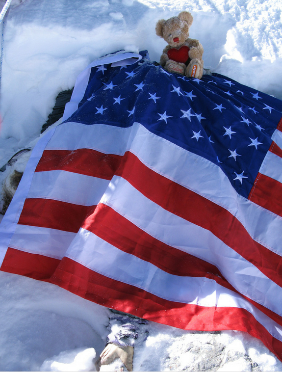 
Một cái xác được bọc cờ Mỹ.
