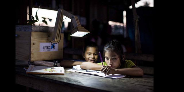  Những đứa trẻ làm bài tập về nhà dưới ánh đèn mọc từ cây xanh. 