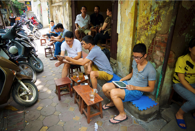   Người Việt dùng smartphone, tablet để lên mạng tại một quán cà phê vỉa hè Hà Nội. Ảnh: CNET. 