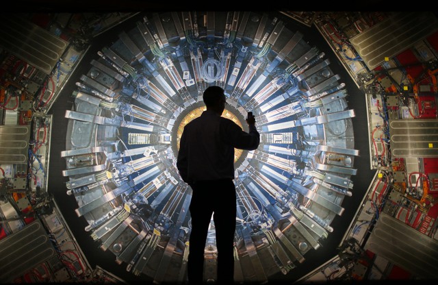  Một người đứng trước bức tranh máy gia tốc hạt tại Bảo tàng khoa học London. 