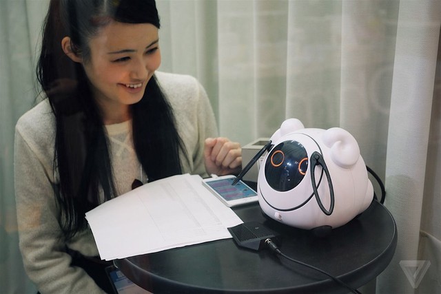  Omnibot Ohanas là một robot trò chuyện có giá 161 USD, trên bàn là người phụ nữ đang hỏi robot về các siêu sao thể thao Nhật Bản. 