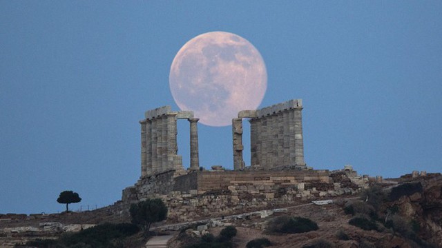 Trăng tròn tại khu đền thờ thần Poseidon cũ ở Athens, Hy Lạp, đêm 20/6. Hiện tượng trăng tròn trùng với hạ chí đánh dấu sự kiện thiên văn kỳ thú lần đầu tiên xảy ra trong 50 năm qua. Tuỳ thuộc múi giờ và vị trí trên trái đất, người dân thế giới có cơ hội chứng kiến hiện tượng trăng tròn cùng ngày hạ chí vào ngày 20/6 đến 21/6. Ảnh: AP