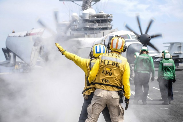  Một binh sỹ áo vàng báo hiệu chỉ dẫn cho chiếc máy bay chở hàng C-2A Greyhound trên boong tàu của sân bay USS Ronald Reagan. 