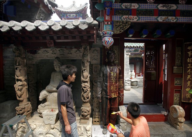 Bolin được các trợ lý của mình sơn vẽ sao cho ăn nhập với bức tường của một ngôi chùa cổ tại trung tâm Bắc Kinh.