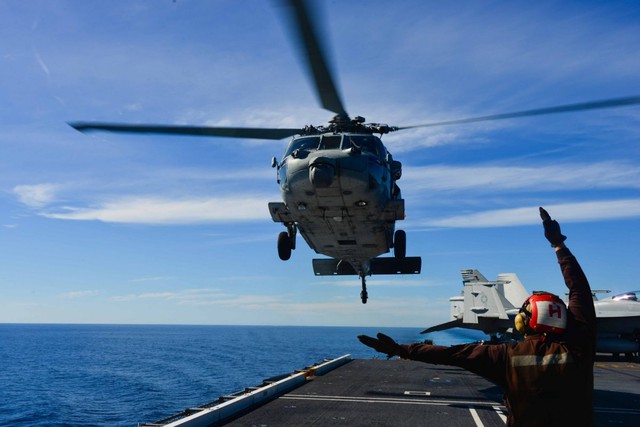  Một binh sỹ đang chỉ dẫn cho chiếc SH-60 Sea Hawk hạ cánh trên boong tàu USS John C. Stennis. 