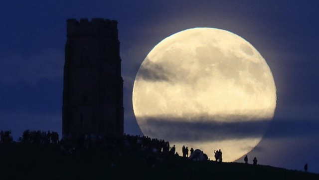 Người dân vùng Somerset, Anh, quan sát trăng tròn đêm hạ chí. Đối với người dân ở bán cầu Bắc, hạ chí đánh dấu thời điểm trục phía bắc của trái đất nghiêng về phía mặt trời, tạo ra những ngày dài nhất và đêm ngắn nhất trong năm. Ảnh: AFP