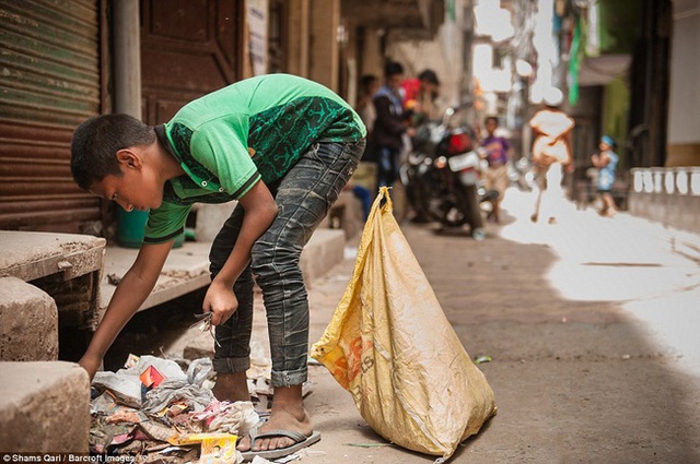 Cậu bé Asif mười tuổi đang tìm những mẩu dây điện nhỏ bên lề đường.