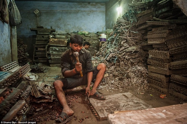 Ramcharan (phía trước) và bạn của anh Harish, đang tiếp tục công việc phân loại sau khi thu thập kim loại từ các mặt hàng phế thải.