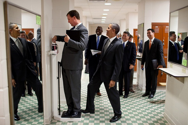 Ông Obama tinh nghịch đặt chân của mình lên cân khi Giám đốc Vận chuyển Marvin Nicholson đang đứng trên cân