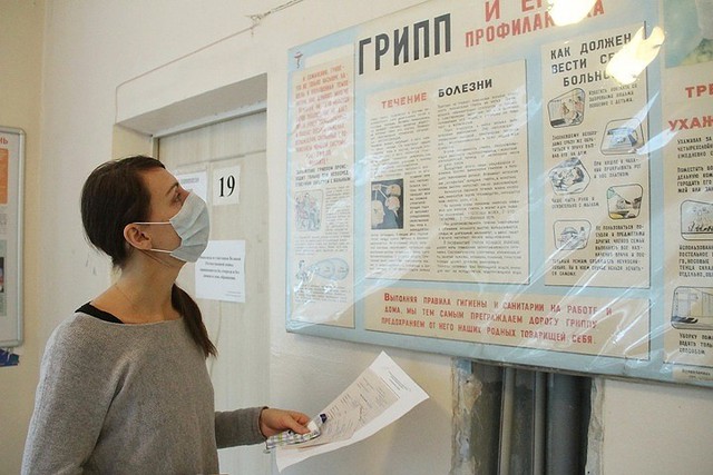 Một phụ nữ đang đọc hướng dẫn phòng tránh bệnh cúm 