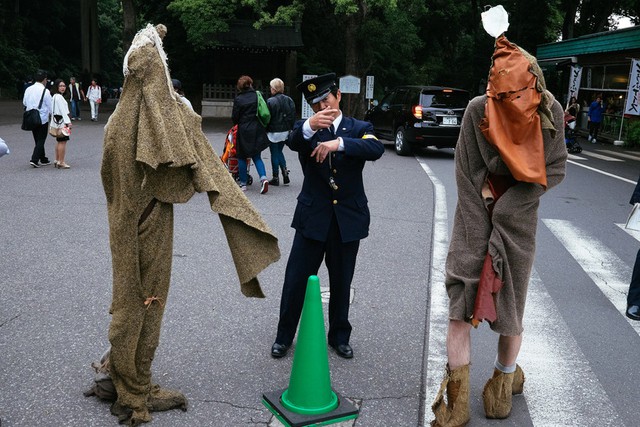 
Chú cảnh sát đang cố gắng hướng dẫn cho hai cosplayer trong trang phục kỳ quái
