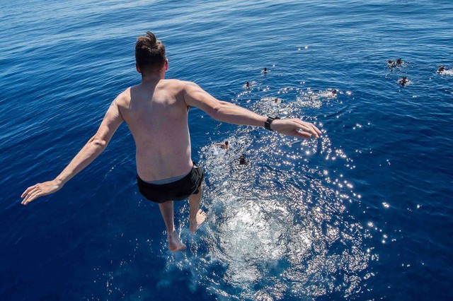  Một thủy thủ chiến hạm USS Mobile Bay phấn khích nhảy xuống biển Thái Bình Dương. 