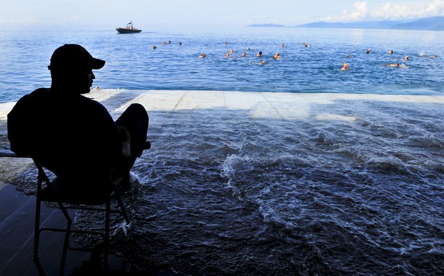  Một giám sát viên của tàu USS Cleveland đang trông chừng các thủy thủ bơi lội gần vùng biển Papua New Guinea. 