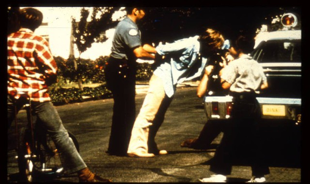 Cảnh sát Stanford còng tay tù nhân số 8612 trước khi vận chuyển anh ta đến nhà tù.