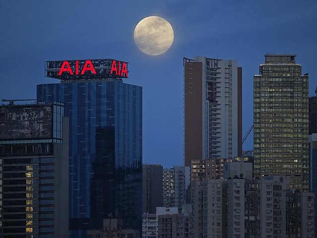 The moon over high-rise buildings in Hong Kong. AP Photo/Vincent Yu
