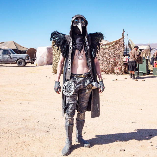 
Một người tham dự trong trang phục dựa theo loài quạ trước trại của bộ lạc mình
