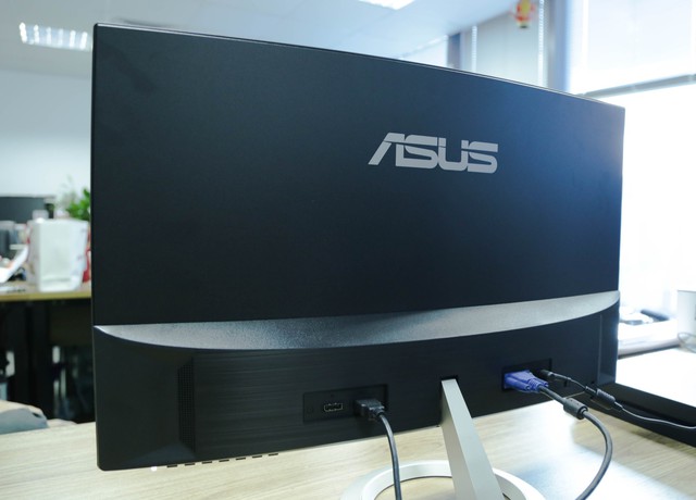 
Mặt sau sản phẩm với logo ASUS lớn, phía dưới là loa, các cổng kết nối, nút menu ở dưới cùng.
