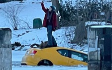 Xe sụt xuống hố băng, cô nàng thản nhiên leo lên nóc ngồi selfie với chiếc xe đang chìm nghỉm